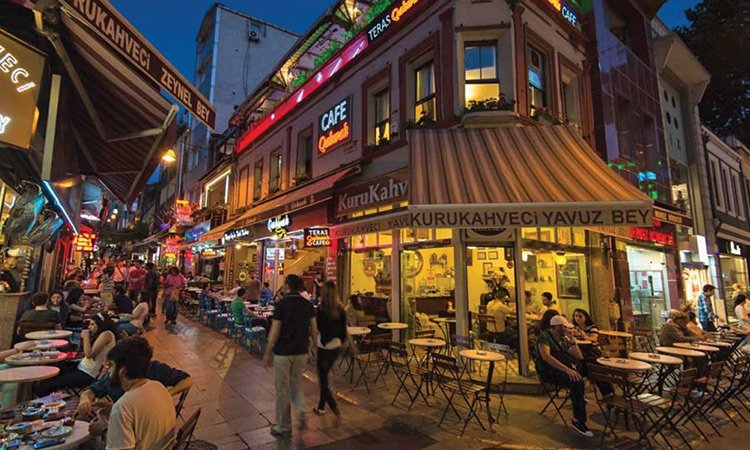 A lively bar or restaurant in Kadikoy at night, with dim lights and groups socializing.